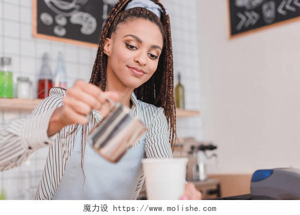 年轻的非洲裔美国咖啡师把牛奶倒进杯咖啡